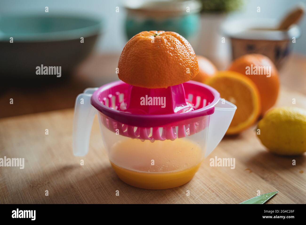 Eine Orange auf einer Quetschpresse, bevor sie gepresst wird, um Orangensaft zu machen. Stockfoto