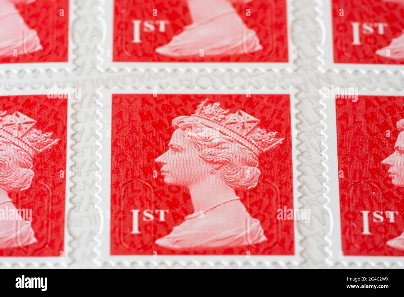Scharlachrote Makroaufnahmen von Royal Mail erstklassige Briefmarken für Porto mit einem Bild des Kopfes von Königin Elizabeth II., große Schärfentiefe. VEREINIGTES KÖNIGREICH Stockfoto