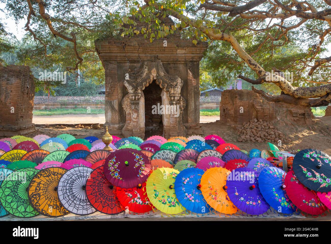 Farbenfrohe Regenschirme und Überreste historischer buddhistischer Tempel in Mandalay, Myanmar Stockfoto