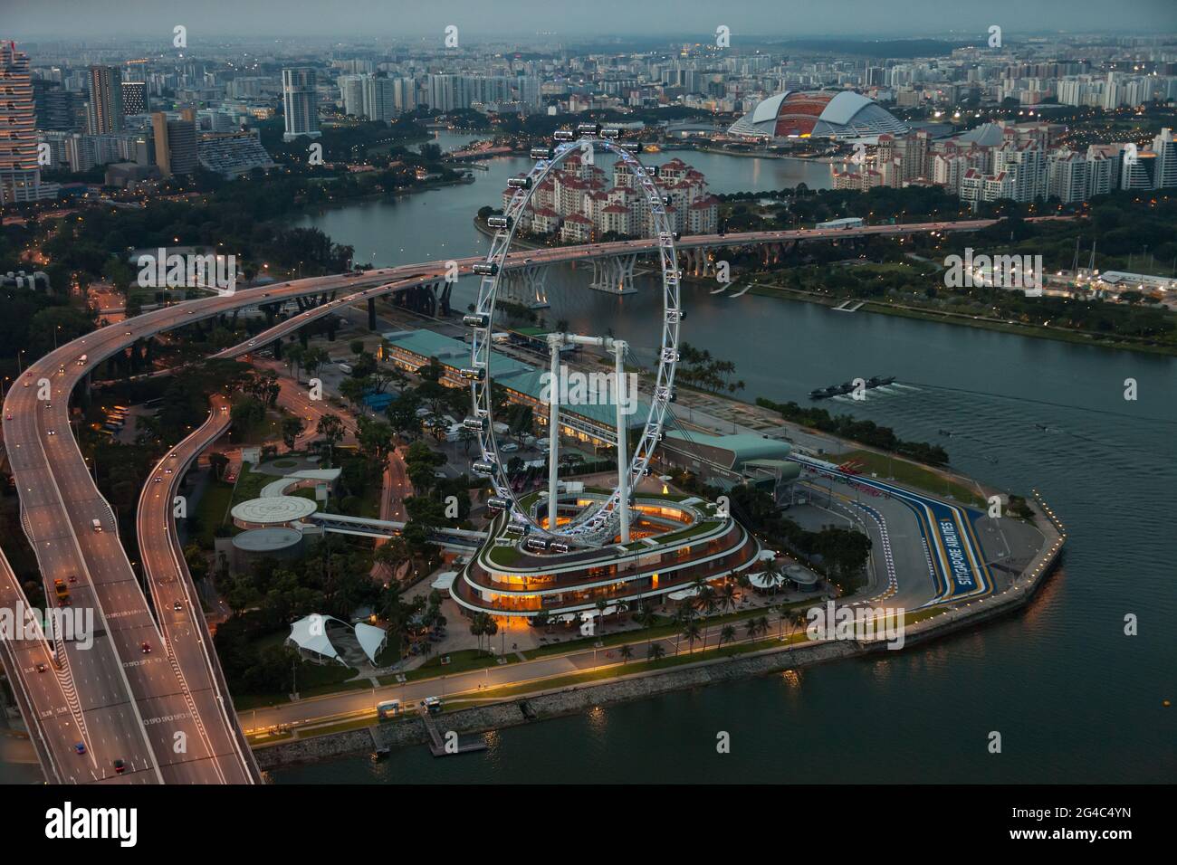 Blick auf den Singapore Flyer und die Marina Bay zur elektrischen Stunde, wenn die Sonne untergeht Stockfoto