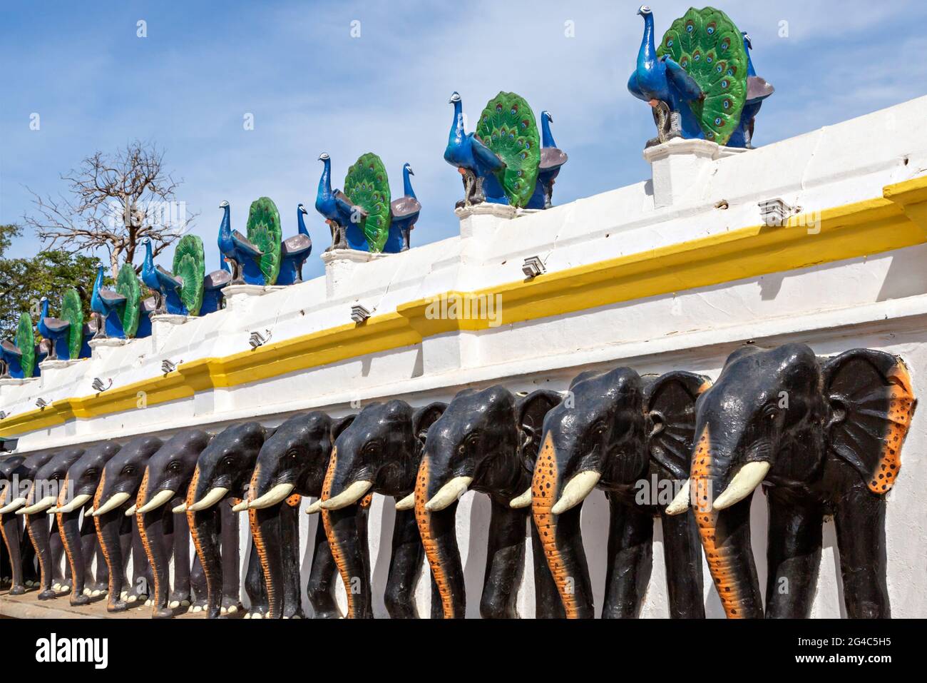 Reihe von Pfau- und Elefantenstatuen in der Hofmauer des Kataragama-Tempels in Sri Lanka. Stockfoto