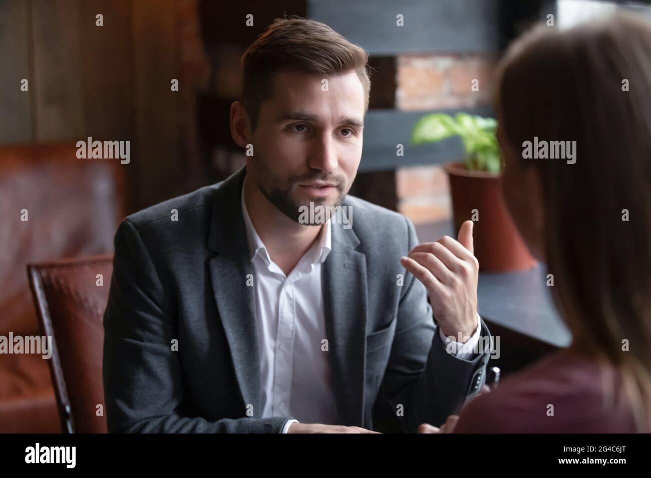 Glücklicher junger Mann im Gespräch mit Freund im Café beteiligt. Stockfoto