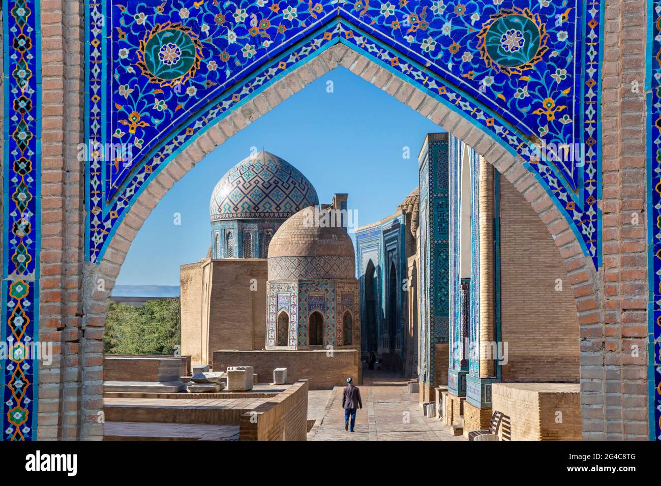 Blick über die Mausoleen und Kuppeln des historischen Friedhofs von Shahi Zinda durch ein Bogentor, Samarkand, Usbekistan. Stockfoto