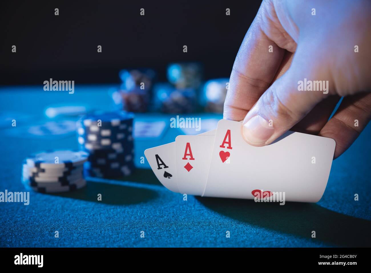 Hand nimmt Karten, drei Asse, spielt Casino Poker. Hintergrund mit Kopierbereich Stockfoto