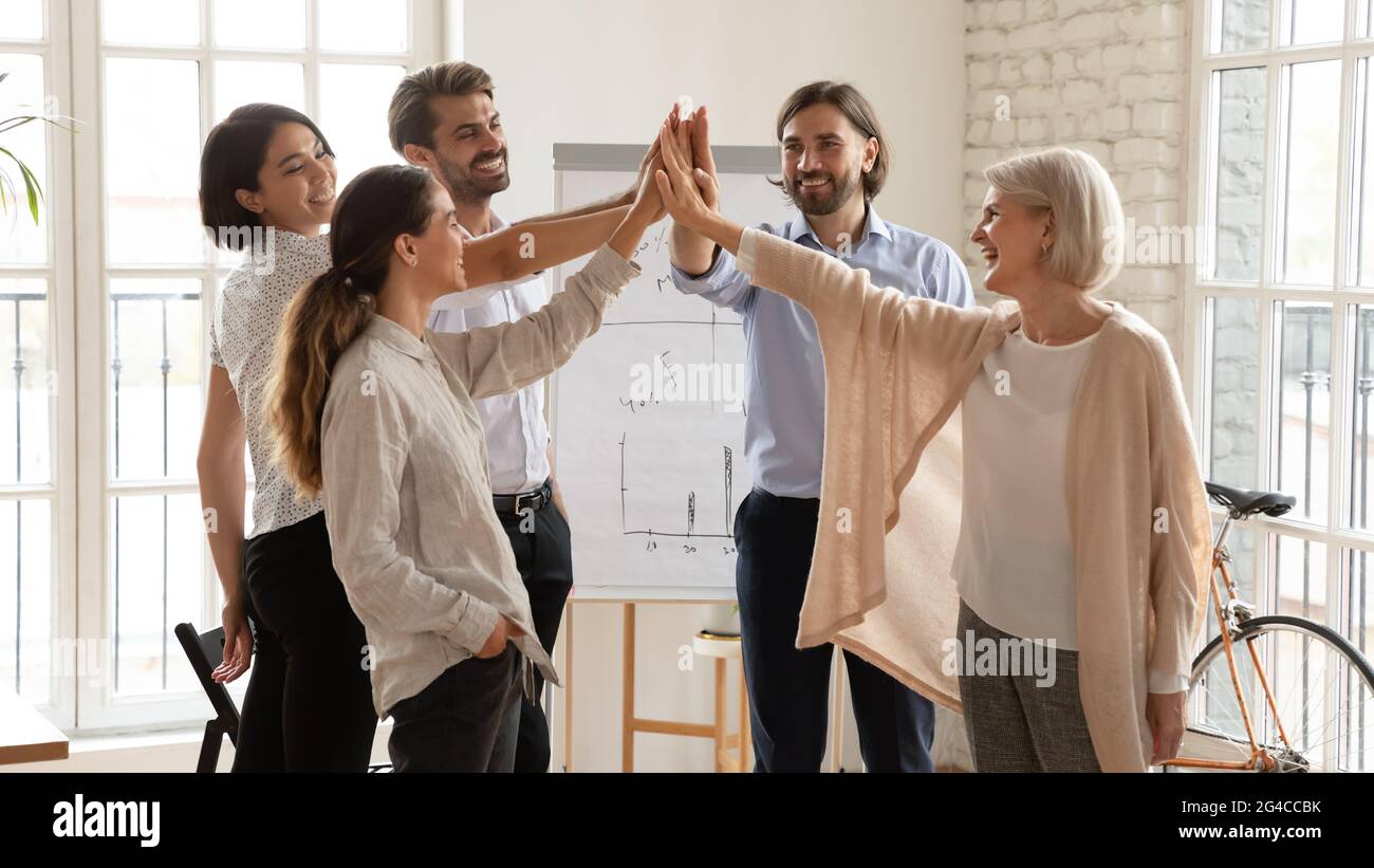 Glückliche, multiethnische Geschäftsleute, die bei der Besprechung hohe fünf geben Stockfoto