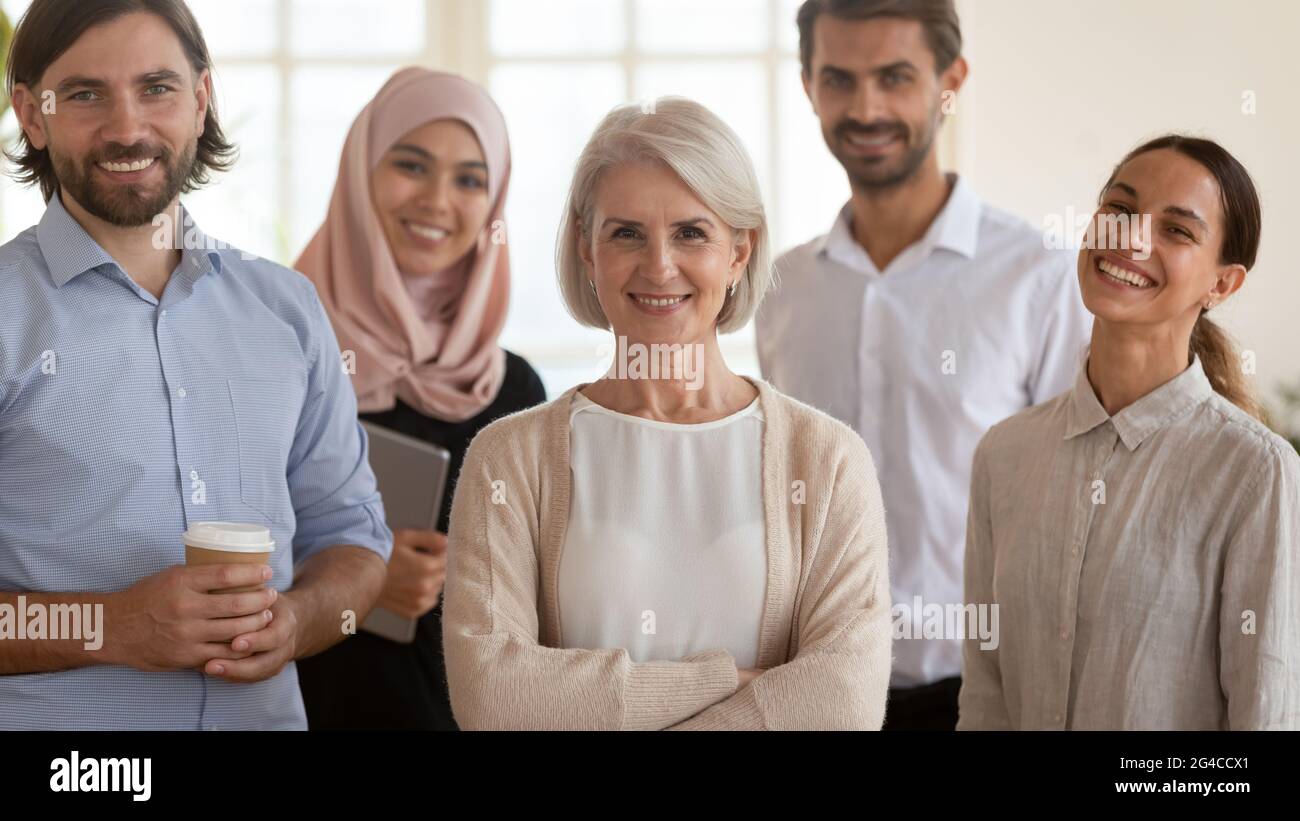 Porträt mit lächelnden, multiethnischen Mitarbeitern und einer reifen Führungskraft Stockfoto