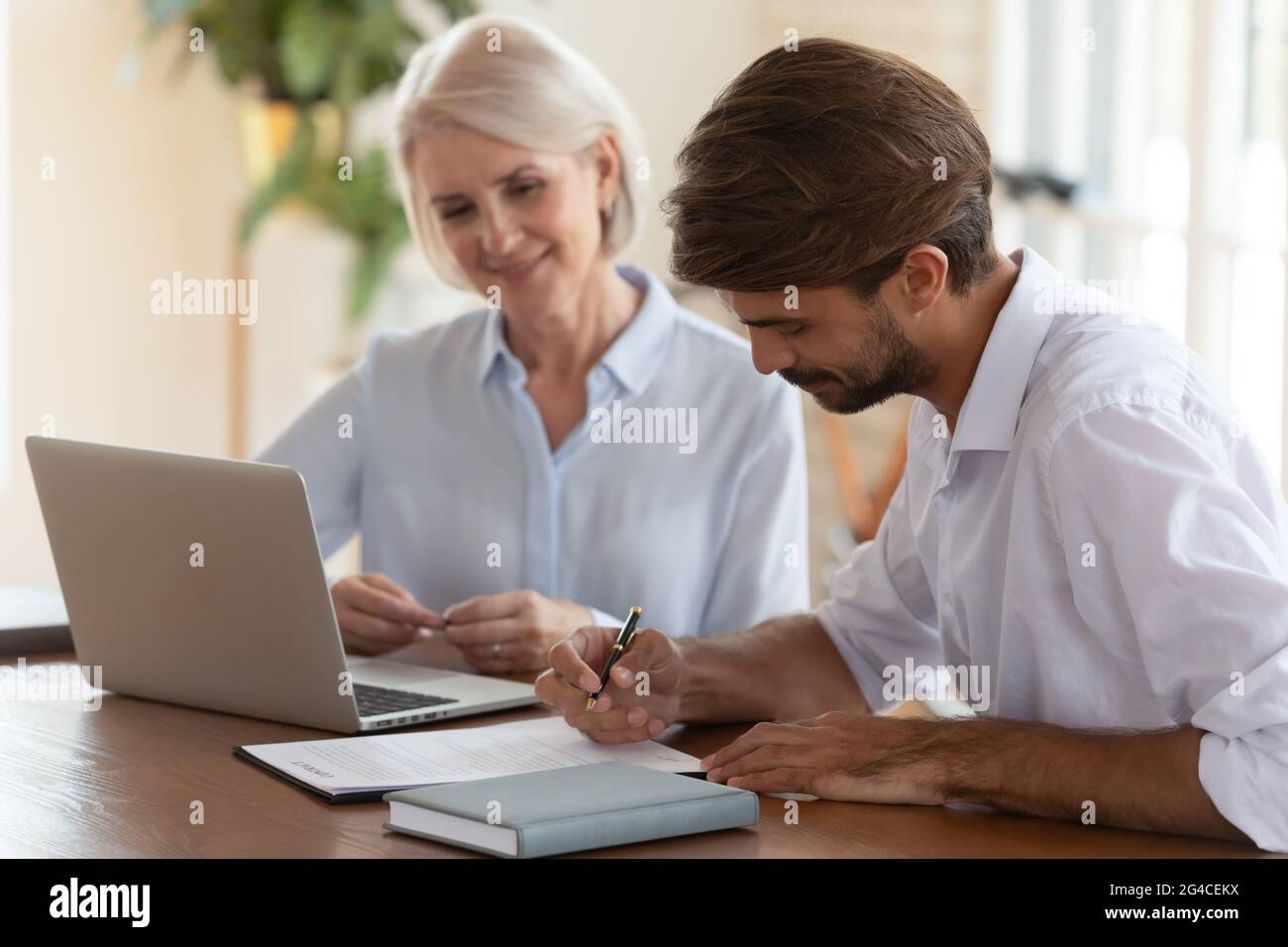 Kunde unterzeichnet Vertrag mit Manager mittleren Alters nach erfolgreichen Verhandlungen Stockfoto