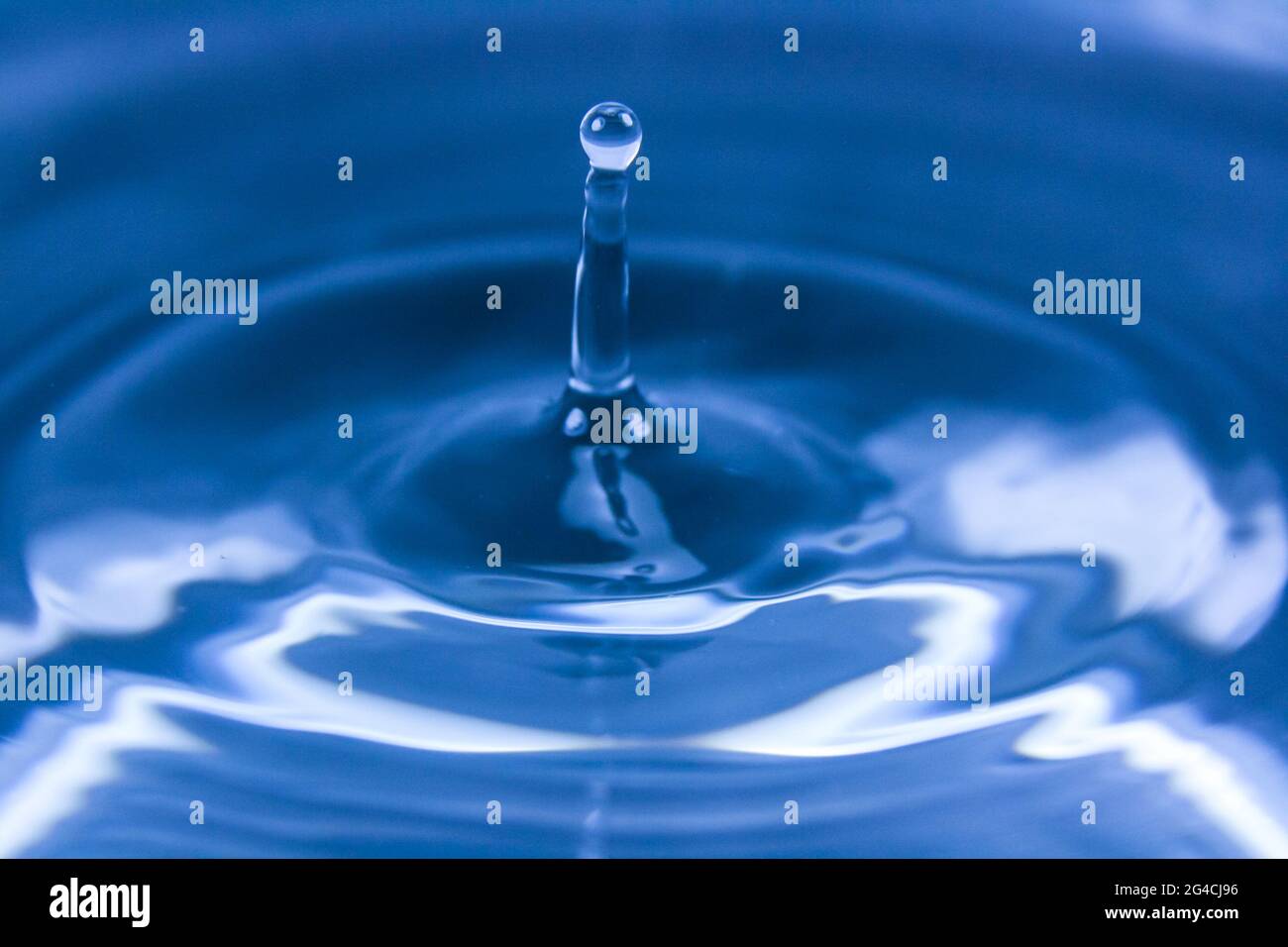 Die schöne Tapete von Tropfen, der auf das Wasser fällt und Wellen macht Stockfoto