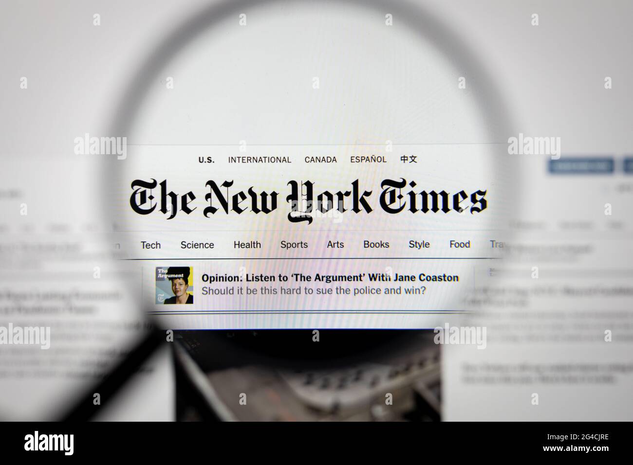 Das Firmenlogo der New York Times auf einer Website, auf einem Computerbildschirm durch eine Lupe gesehen. Stockfoto
