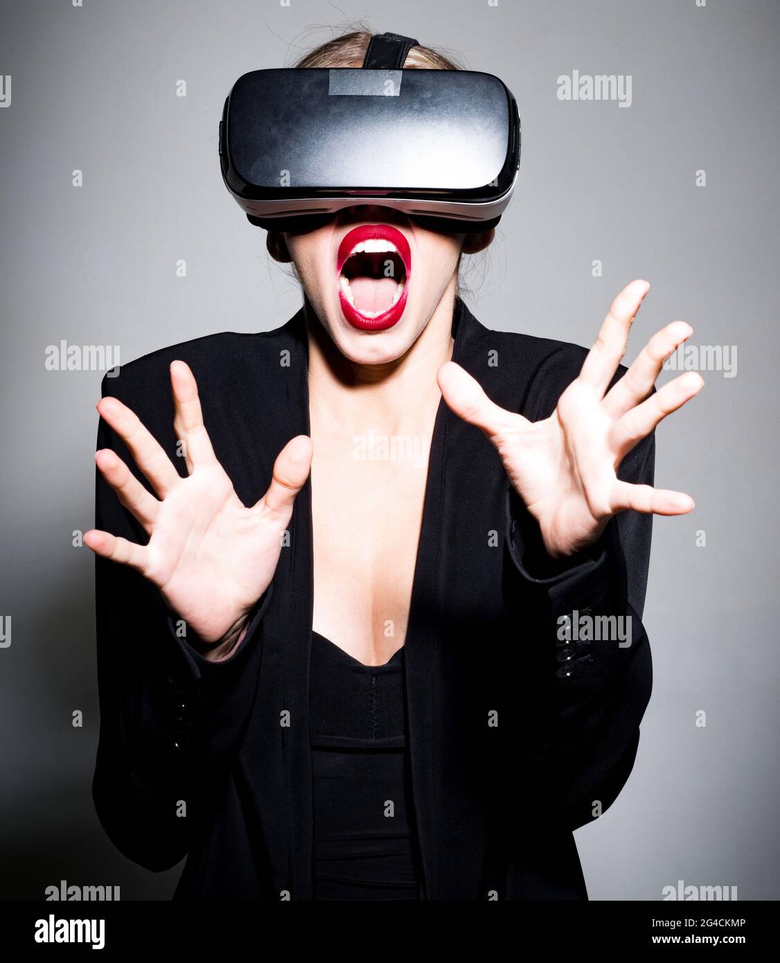 Verängstigte Frau mit Virtual-Reality-Gerät. Schönes Mädchen in VR-Brille. Entertainment und innovatives Technologiekonzept. Stockfoto
