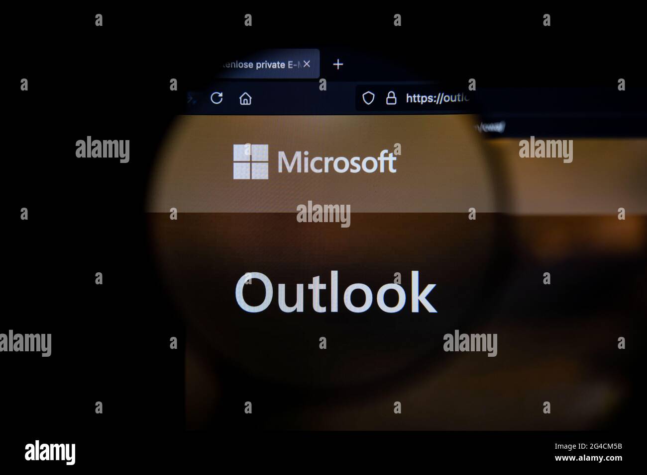 Microsoft Outlook-Firmenlogo auf einer Website, auf einem Computerbildschirm durch eine Lupe gesehen. Stockfoto