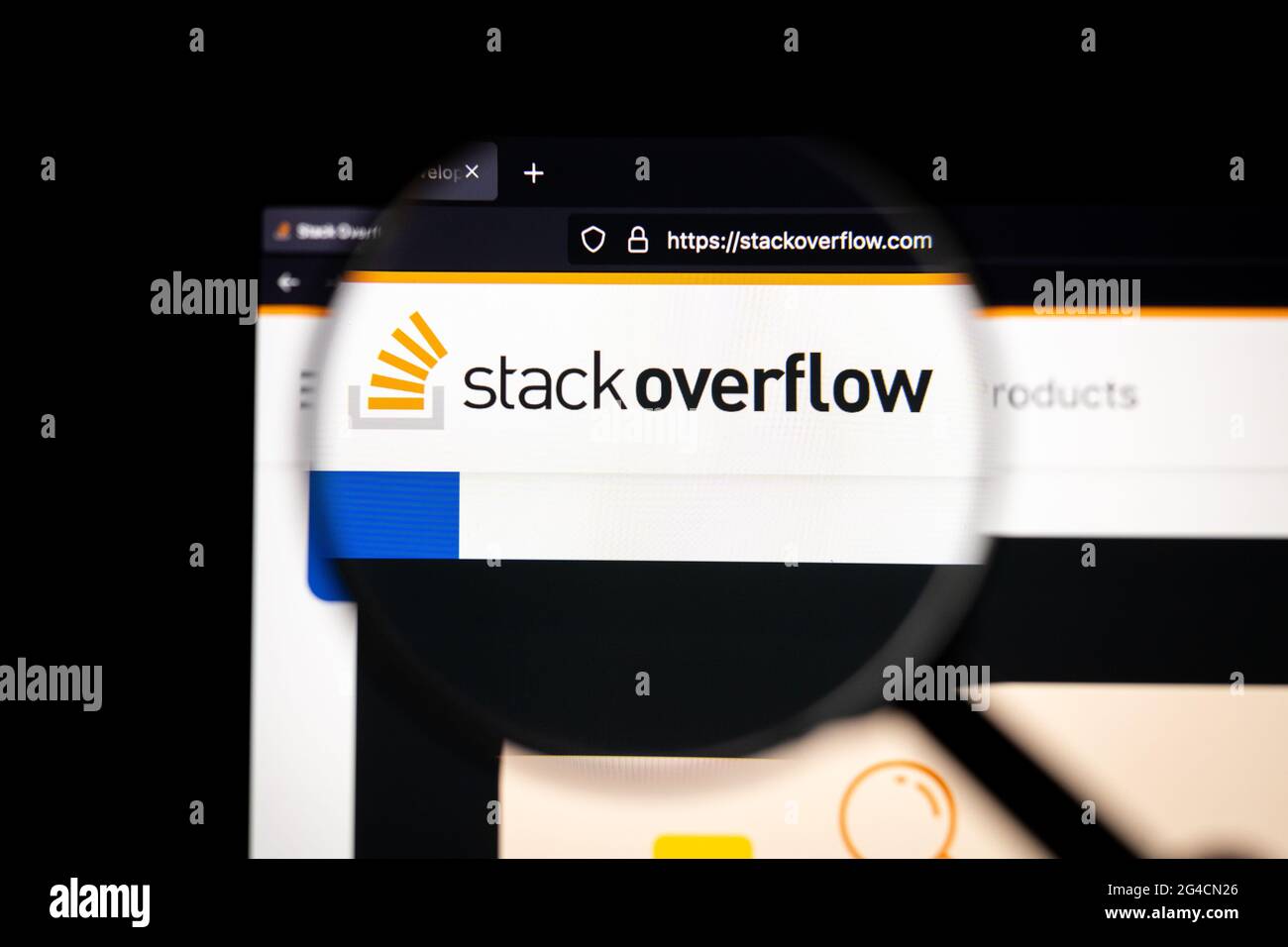 Stack Overflow Firmenlogo auf einer Website, auf einem Computerbildschirm durch eine Lupe gesehen. Stockfoto
