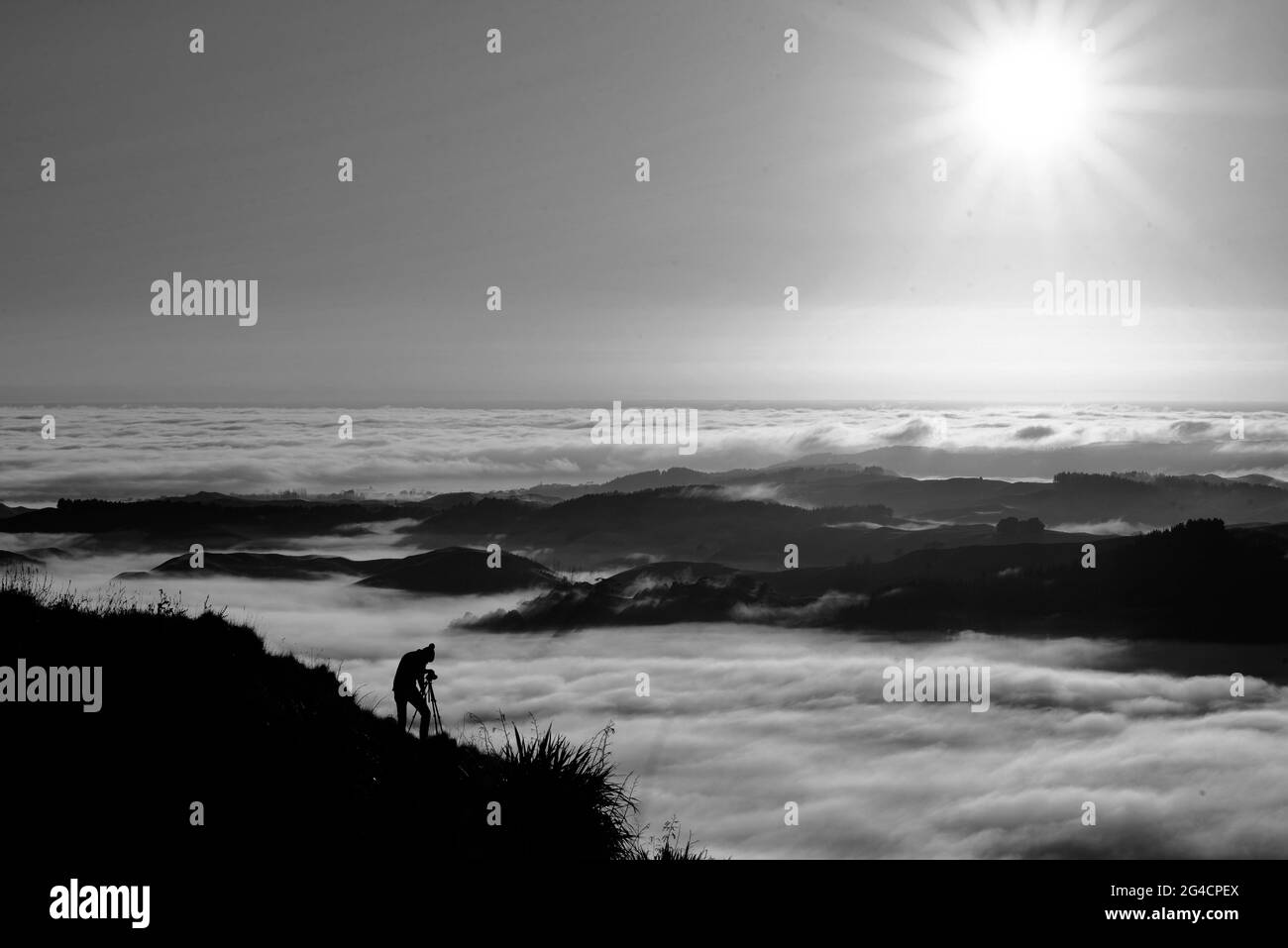 Landschaftsfotograf beim Fotografieren von Sonnenaufgang und Morgennebel auf dem Mata Peak, Hawke's Bay, Neuseeland Stockfoto