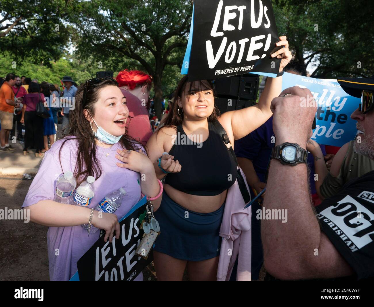 Austin, Texas, USA. Juni 2021. Zwei Frauen rufen einen Mann an, der ein Sturmgewehr auf dem Gelände des Capitols trägt, während Hunderte von texanischen Demokraten sich zusammenrufen, um Wahlrechtsrechnungen zu unterstützen, die im Kongress ins Stocken geraten sind, und die republikanischen Bemühungen anprangere, die Wählerregistrierung und den Zugang zu den Umfragen zu vereiteln. Kredit: Bob Daemmrich/Alamy Live Nachrichten Stockfoto