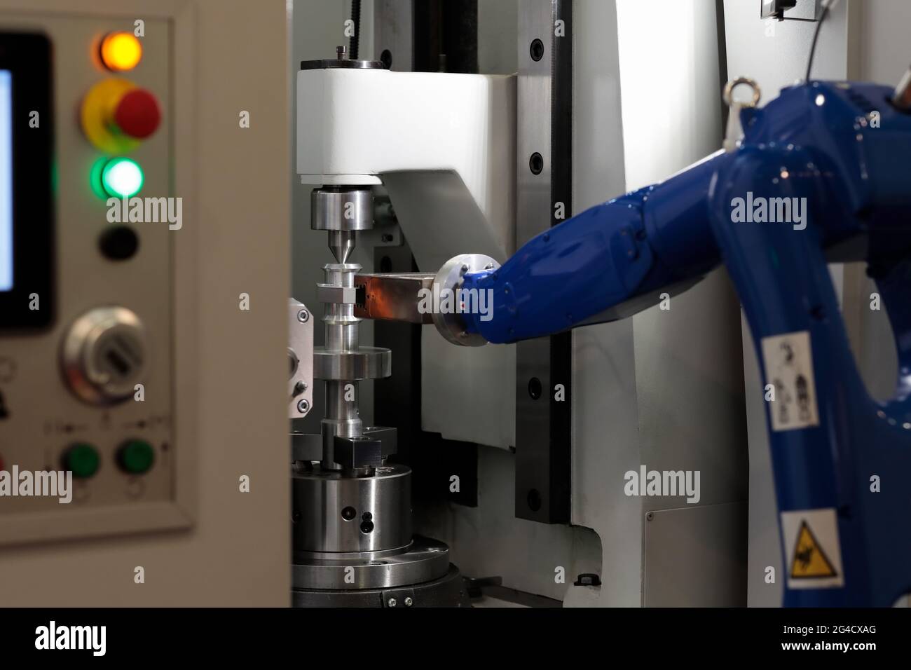 CNC-Maschine und Roboterarm zum Be- und Entladen von Werkstücken. Selektiver Fokus. Stockfoto