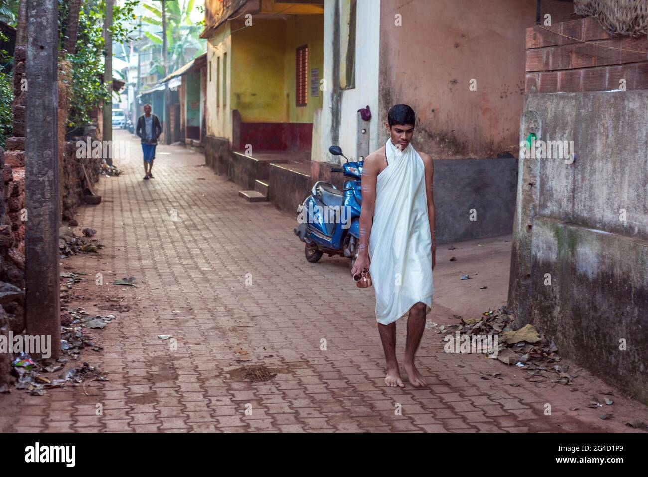 Junge indische hindu-Männer laufen barfuß in seidig weißem Gewand durch die Gasse, Gokarna, Karnataka, Indien Stockfoto