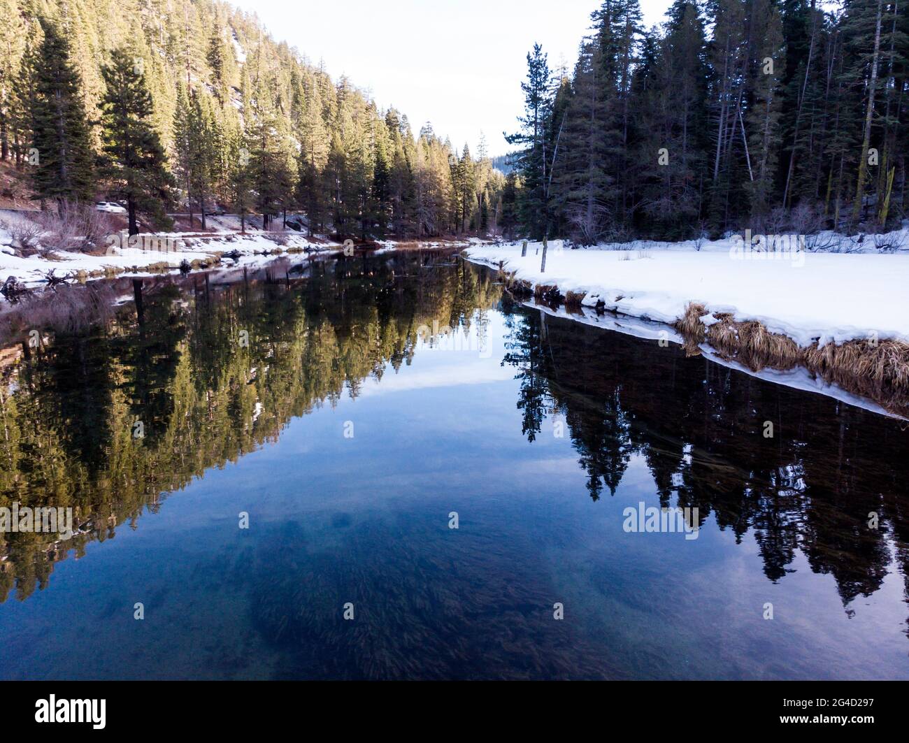 Truckee River im Winter mit Schnee an den Ufern und Baumreflexen Stockfoto