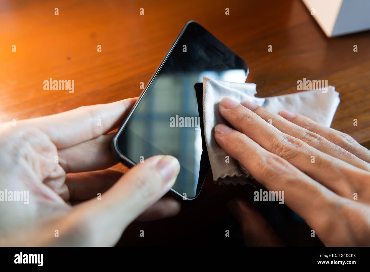 Smartphone-Bildschirm mit Mikrofasertuch reinigen Stockfoto