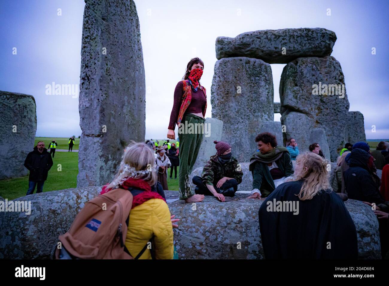 Menschen im Steinkreis während der Sommersonnenwende in Stonehenge, wo einige Menschen über den Zaun sprangen, um den Platz zu betreten und den Sonnenaufgang am längsten Tag in Großbritannien zu beobachten. Die Steine wurden für die Feierlichkeiten, bei denen große Menschenmengen im Kreis zu sehen sind, aufgrund der Coronavirus-Lockdown-Erweiterung offiziell geschlossen. Bilddatum: Montag, 21. Juni 2021. Stockfoto