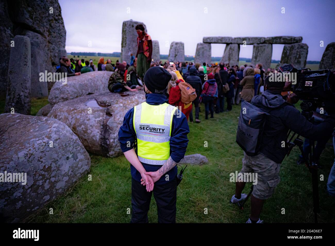 Die Wachleute feiern während der Sommersonnenwende in Stonehenge, wo einige Menschen über den Zaun sprangen, um den Steinkreis zu betreten und den Sonnenaufgang am längsten Tag in Großbritannien zu beobachten. Die Steine wurden für die Feierlichkeiten, bei denen große Menschenmengen im Kreis zu sehen sind, aufgrund der Coronavirus-Lockdown-Erweiterung offiziell geschlossen. Bilddatum: Montag, 21. Juni 2021. Stockfoto