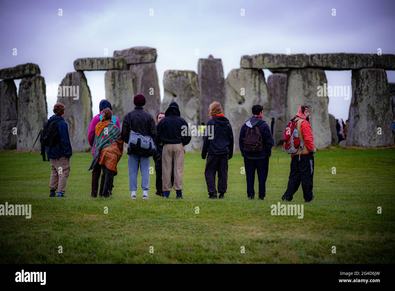Während der Sommersonnenwende in Stonehenge sehen die Menschen die Steine, wo einige Menschen über den Zaun sprangen, um den Steinkreis zu betreten und den Sonnenaufgang am längsten Tag in Großbritannien zu beobachten. Die Steine wurden für die Feierlichkeiten, bei denen große Menschenmengen im Kreis zu sehen sind, aufgrund der Coronavirus-Lockdown-Erweiterung offiziell geschlossen. Bilddatum: Montag, 21. Juni 2021. Stockfoto