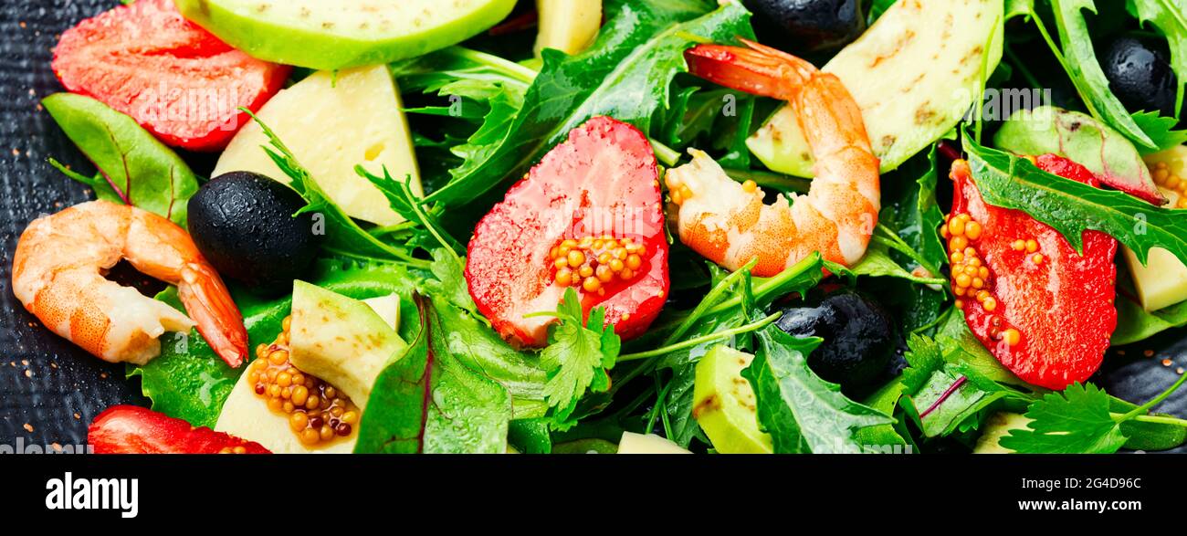 Diätsalat mit Garnelen, Erdbeeren, Avocado und Kräutern. Hintergrund des Essens, langes Banner Stockfoto