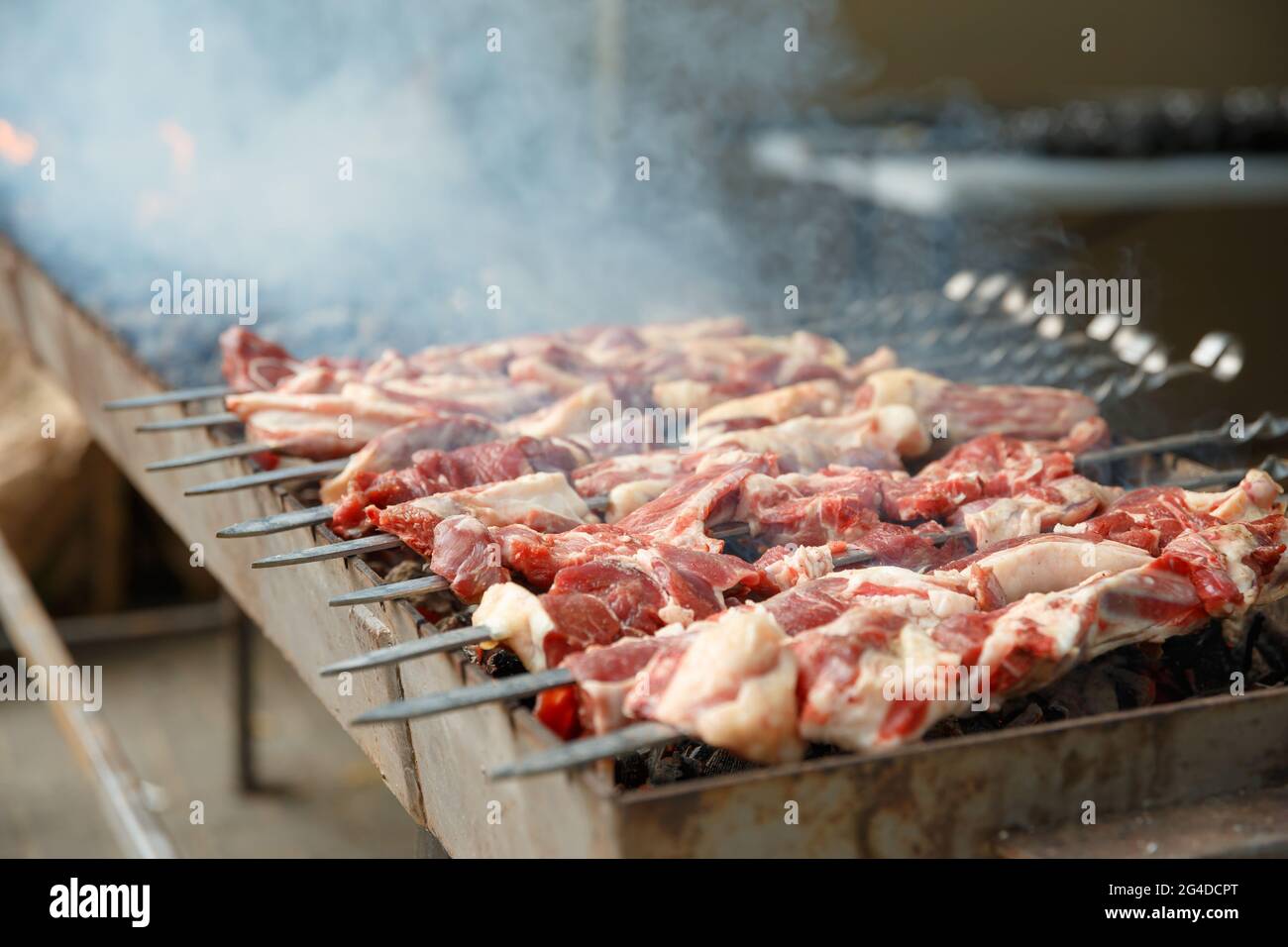 Lammspieße, die auf Spieße aufgereiht sind, werden auf dem Grill gegrillt Stockfoto