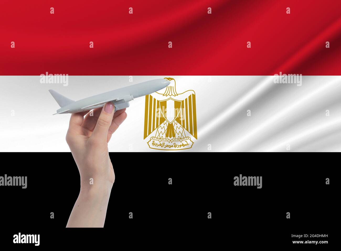 Flugzeug in der Hand mit der Nationalflagge Ägyptens Reise nach Ägypten. Stockfoto