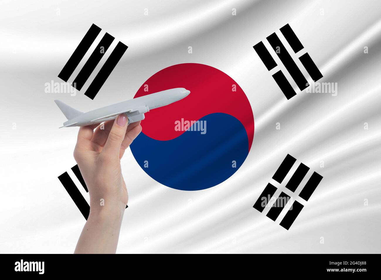 Flugzeug in der Hand mit der Nationalflagge von Südkorea Reise nach