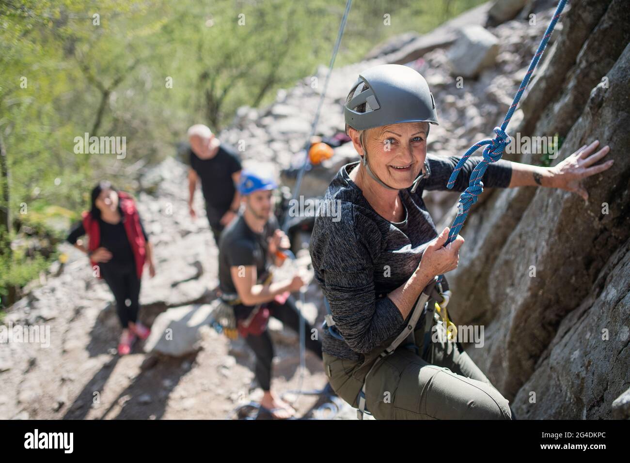 Gruppe von Senioren mit Lehrer Klettern Felsen im Freien in der Natur, aktiven Lebensstil. Stockfoto