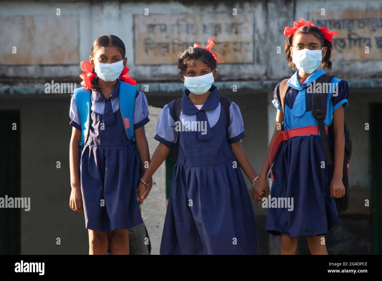 indische Dorf Regierung Schulmädchen tragen Maske stehen in der Schule Stockfoto