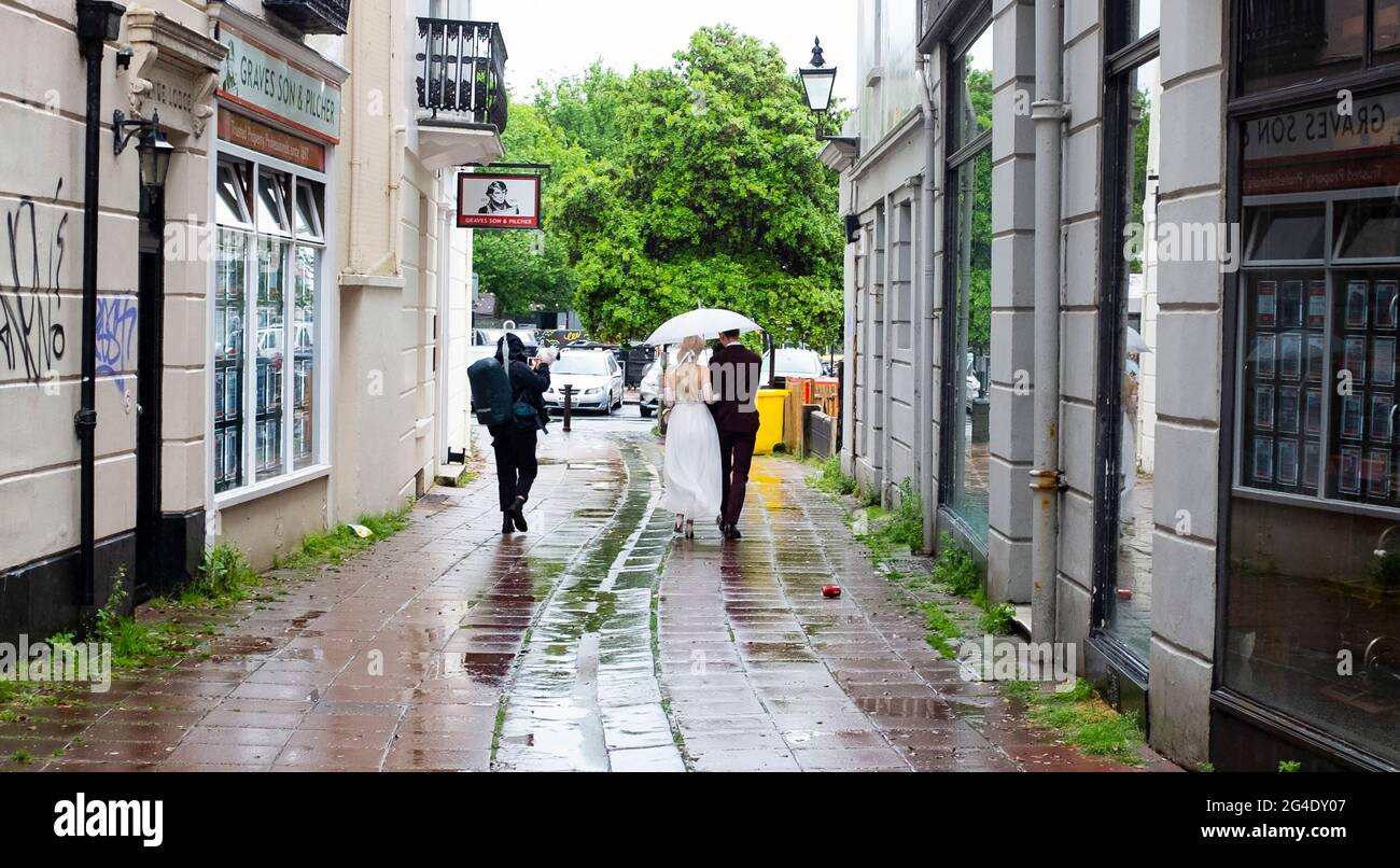 Brighton UK 21. Juni 2021 - EINE Braut und ein Bräutigam lassen sich heute in Brighton nicht vom Sommersonnenwende-Regen verwöhnen : Credit Simon Dack / Alamy Live News Stockfoto