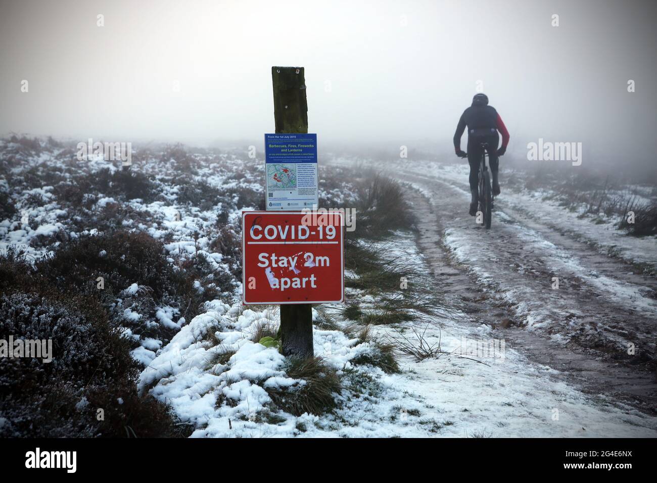 Ein Radfahrer trifft am Silvesterabend 2020 auf Ilkley Moor in West Yorkshire auf eine Nebeldecke. Stockfoto