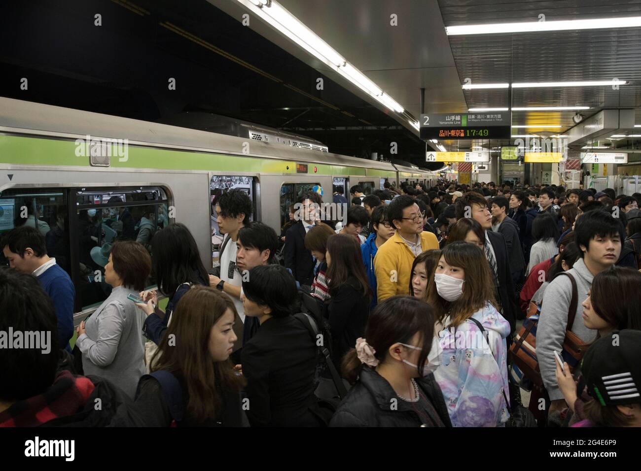 Menschen, die in Tokio zur Hauptverkehrszeit in einen U-Bahn-Zug steigen Stockfoto