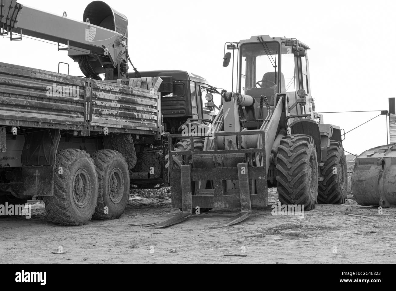 Baumaschinen-LKW mit Kran und Traktor mit Eimer. Stockfoto