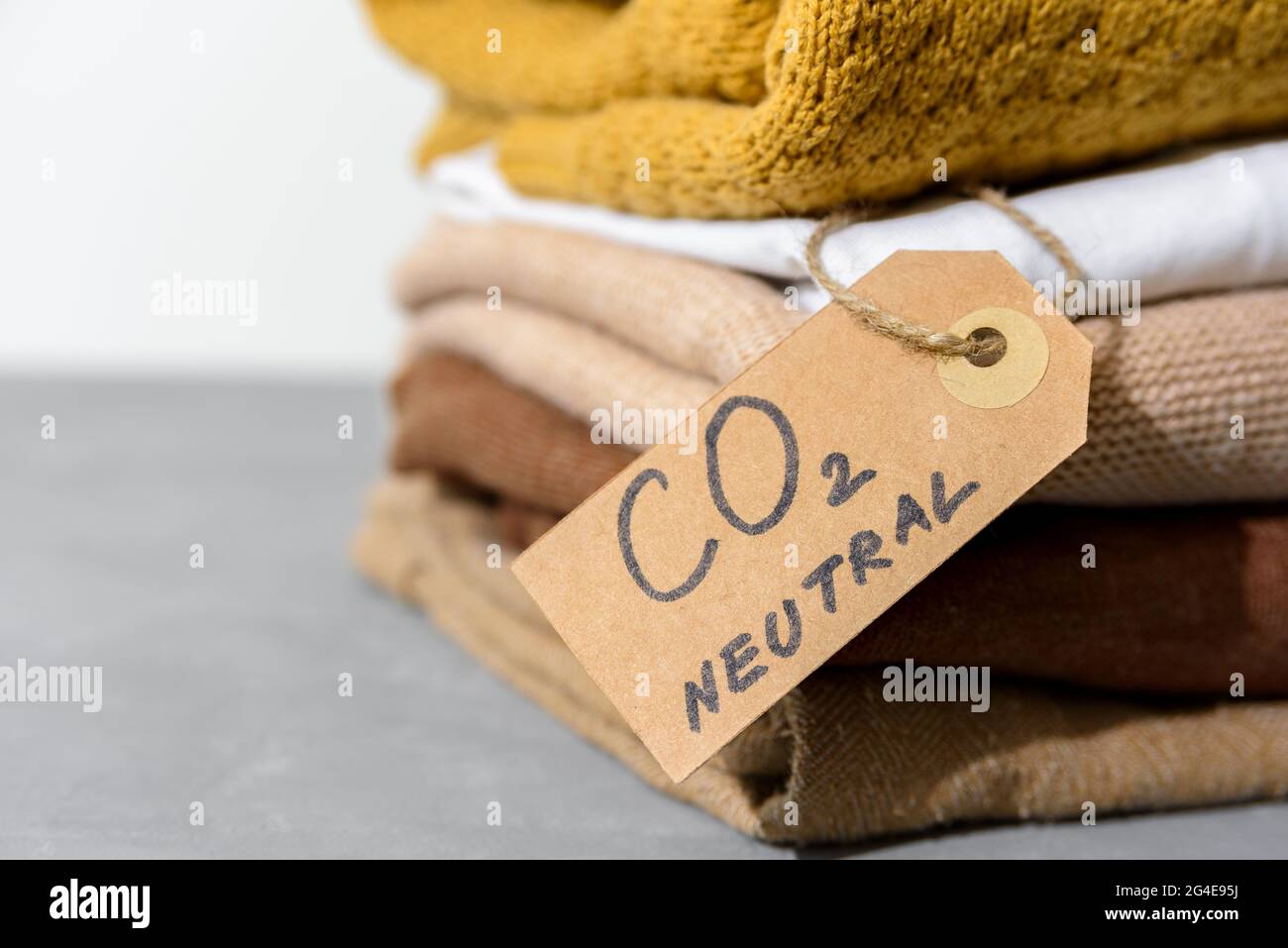Kleidung im Stapel mit Recycling-Etikett für emissionsfreies Papier Stockfoto