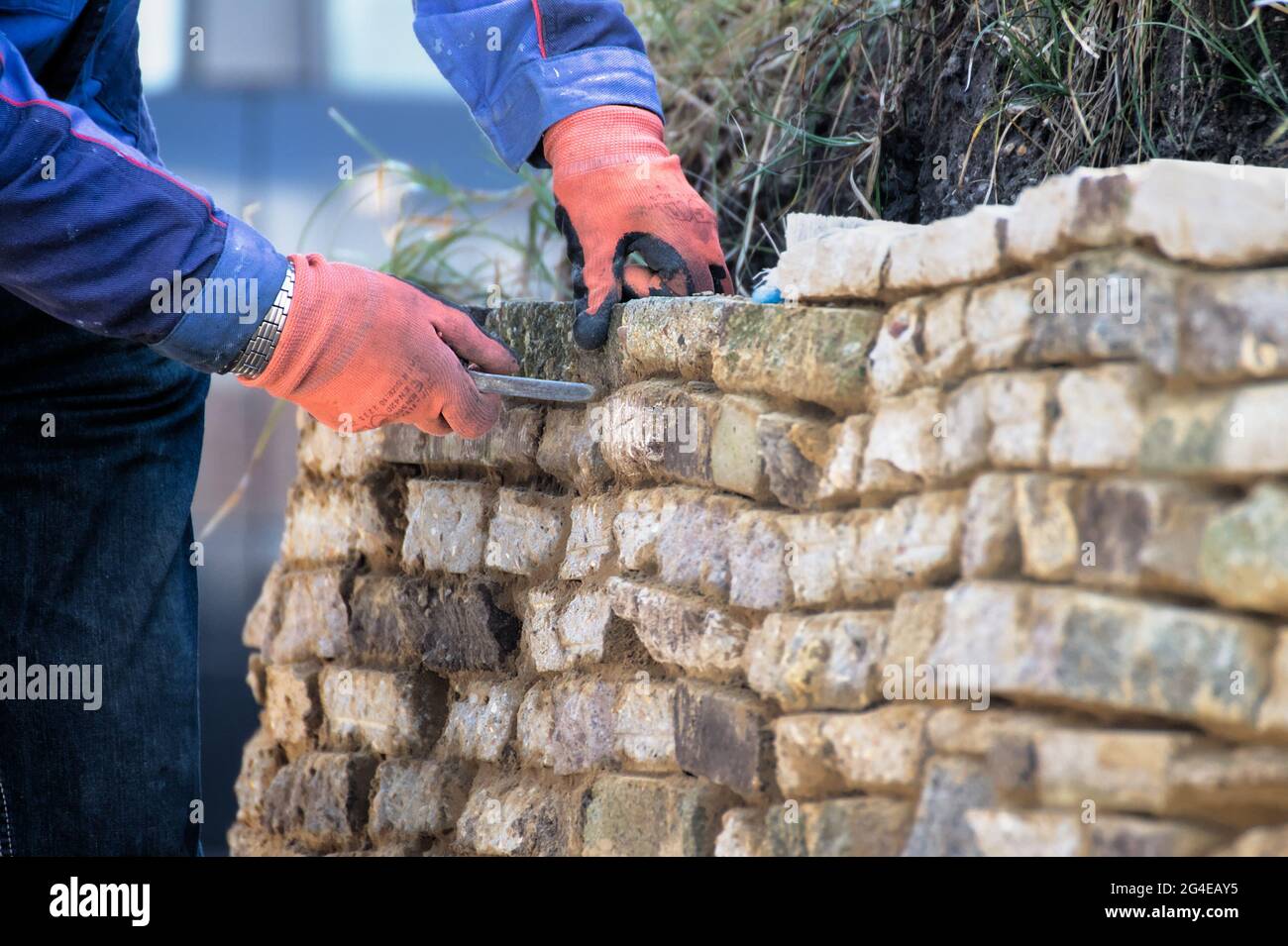 Mann, Baumeister Zementieren, Zeigen EINER rustikalen Steinwand mit EINEM Tuck Pointer Tool England UK Stockfoto