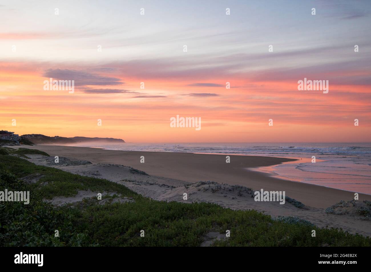 Eine Küstenlandschaft mit einem wunderschönen rosa Sonnenaufgang Stockfoto