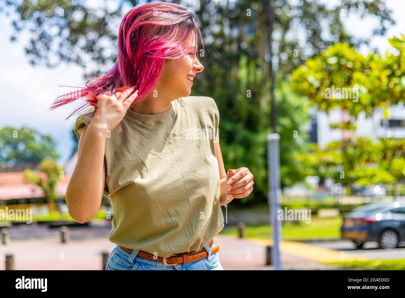 Junge Latina in einem Park, die mit ihren Haaren spielt Stockfoto