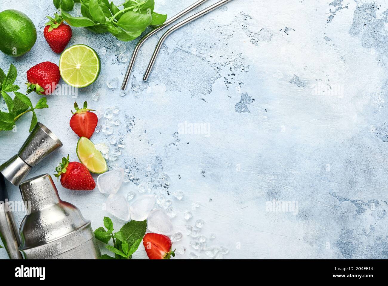 Lebensmittel Frische Zutaten für die Herstellung von Limonade, infundiert entgiftendes Wasser oder Cocktail. Erdbeeren, Limette, Minze, Basilikum, Eiswürfel und Shaker auf blauem oder grauem Sto Stockfoto