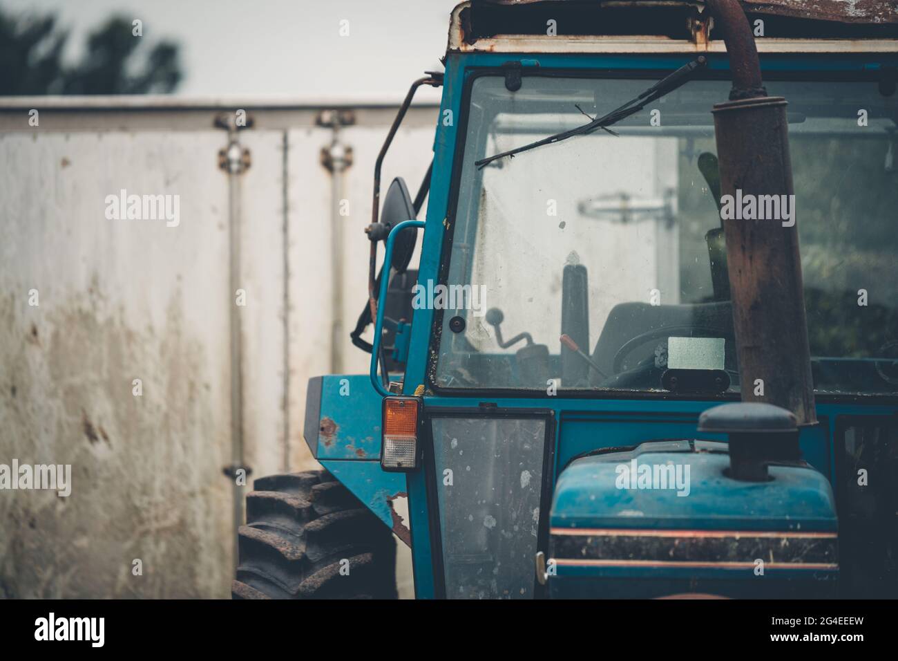 Ein verlassene alte blaue Traktor, der auf einem Feld in Großbritannien mit bewölktem Himmel gelagert wurde Stockfoto