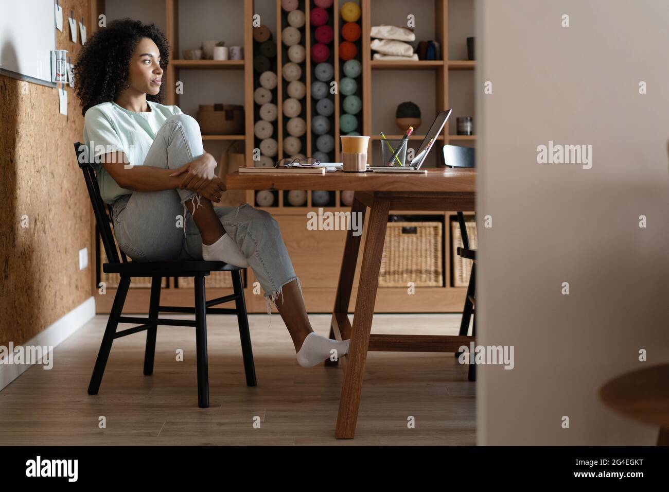 Tausendjährige afroamerikanische Geschäftsfrau liest Papier an ihrem Arbeitsplatz im Büro. Stockfoto