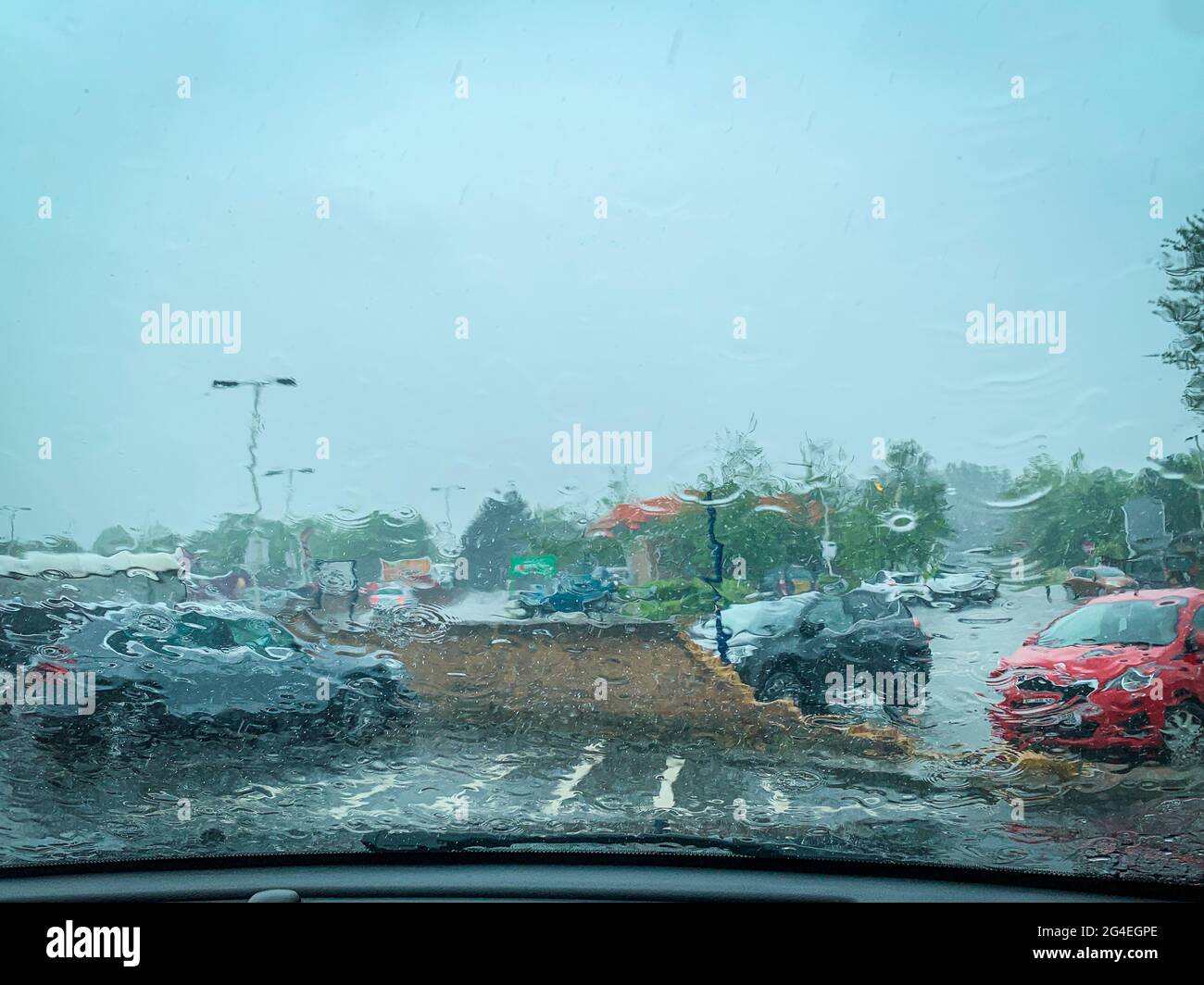 Abstraktes Bild eines sintflutartigen Regens, der an einem Sommermorgen im Juni in Essex, Großbritannien, auf die Windschutzscheibe fällt Stockfoto