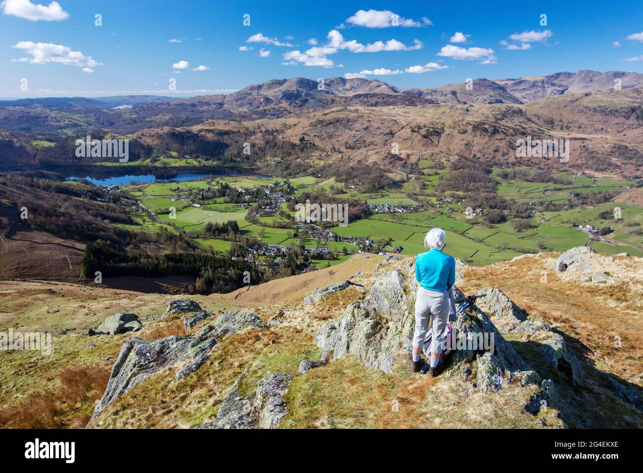 Ein Wanderer, der von Stone arthur auf der Seite von Fairfield, Lake District, Großbritannien, auf Grasmere herabblickt. Stockfoto