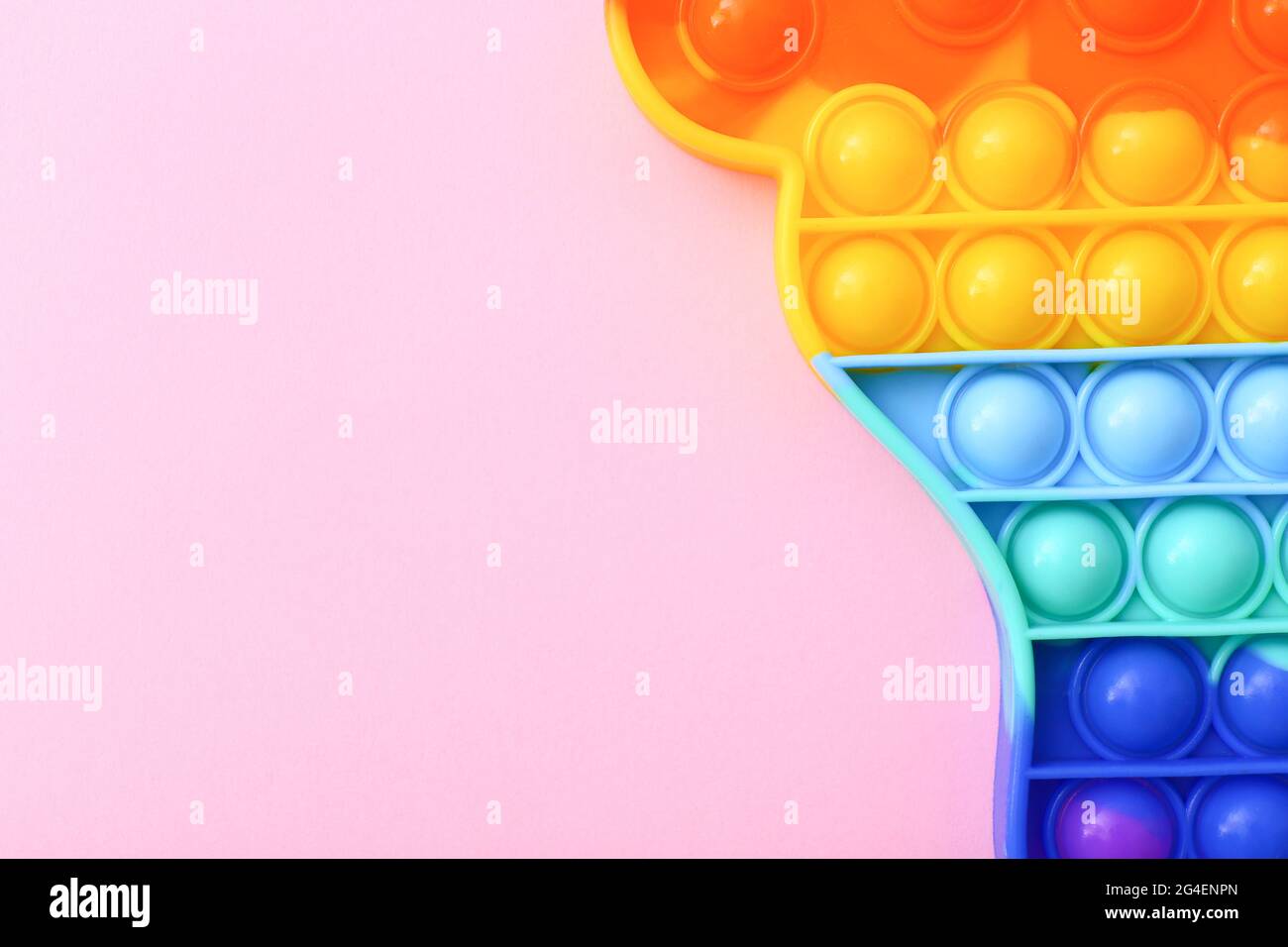 Bunte Antistress Sinnesspielzeug Fidget Push Pop es auf rosa Hintergrund, Draufsicht Stockfoto