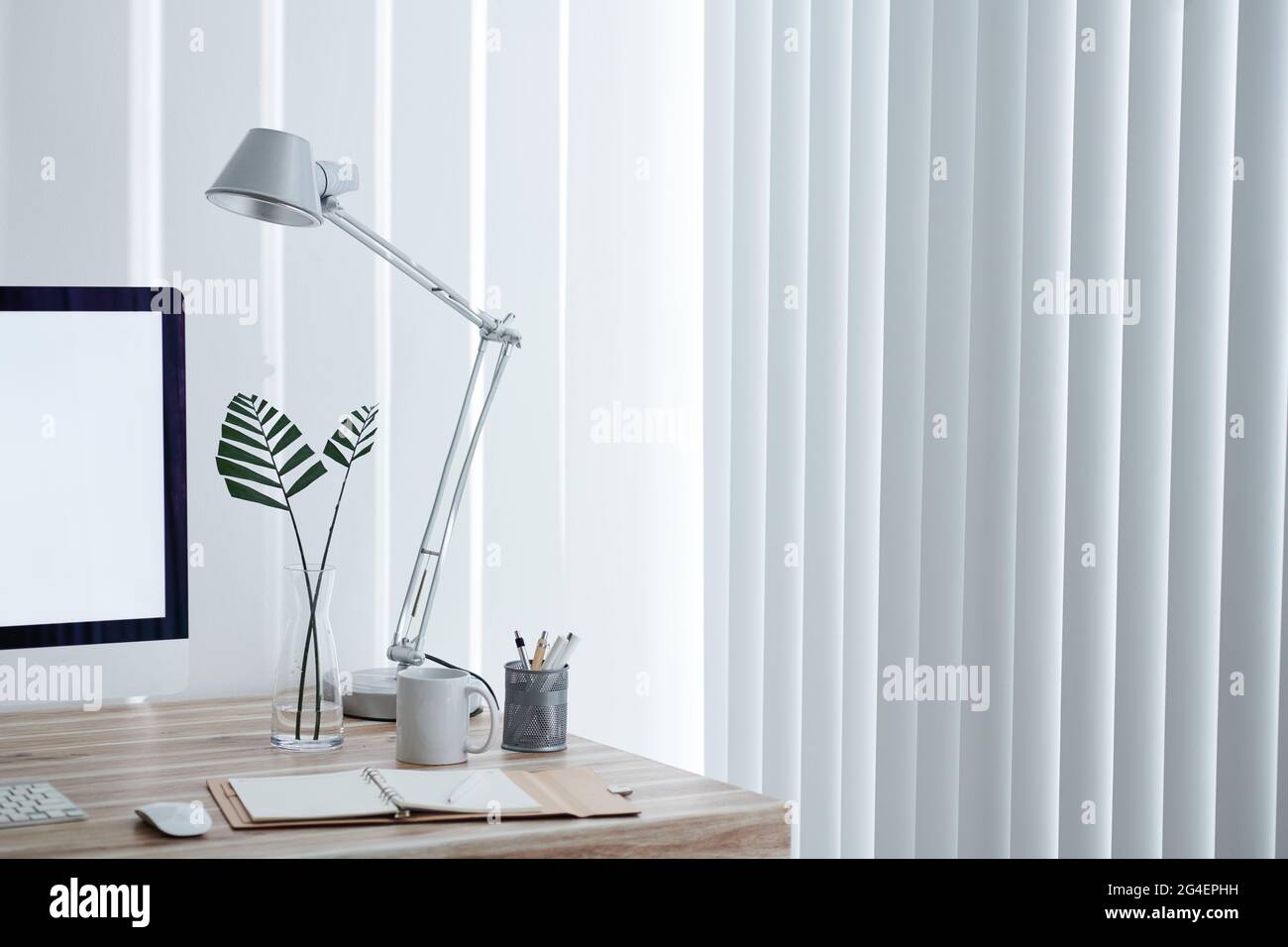 Home Office Schreibtisch des Unternehmers mit Lampe, Computer-Monitor, Planer und Tasse Kaffee Stockfoto