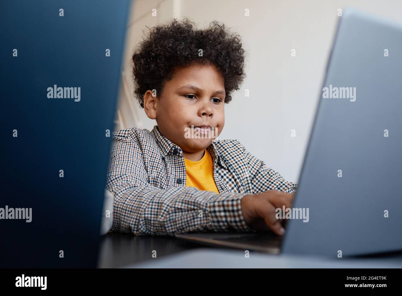 Porträt eines afroamerikanischen Schuljungen, der während des IT-Unterrichts in der Schule einen Laptop verwendet, Speicherplatz kopieren Stockfoto
