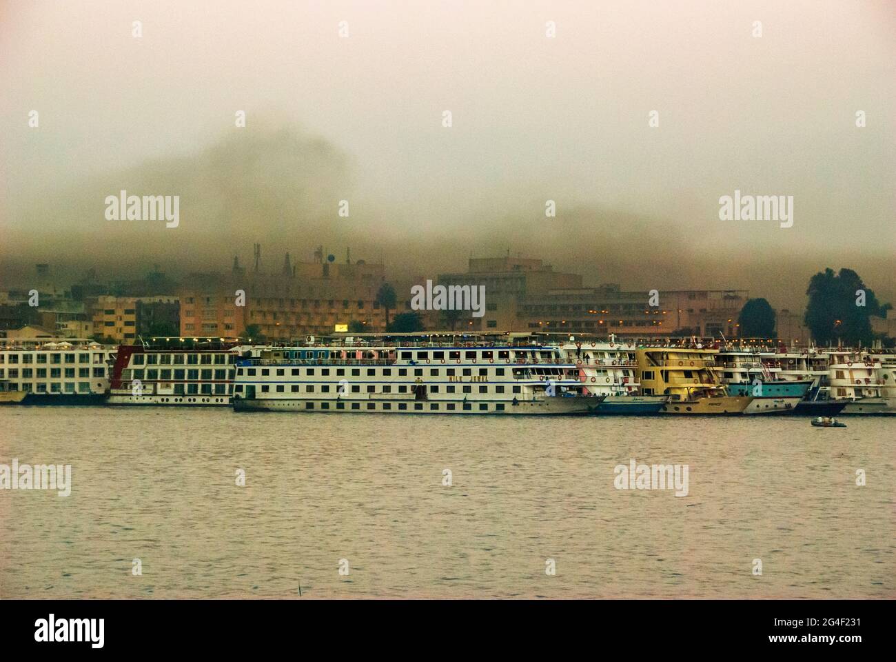 Smog, der von einem Kreuzfahrtboot am Ostufer - Assuan, Oberägypten, angelegt wurde Stockfoto