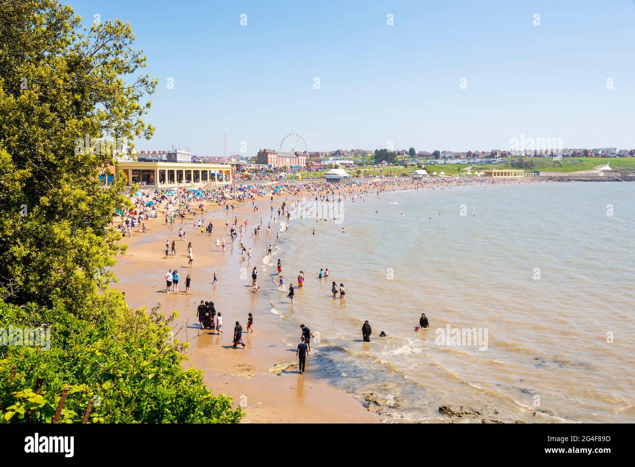 An einem sonnigen Frühlingsfeiertag ist der Strand des Seebadeorts Barry Island voll. Stockfoto