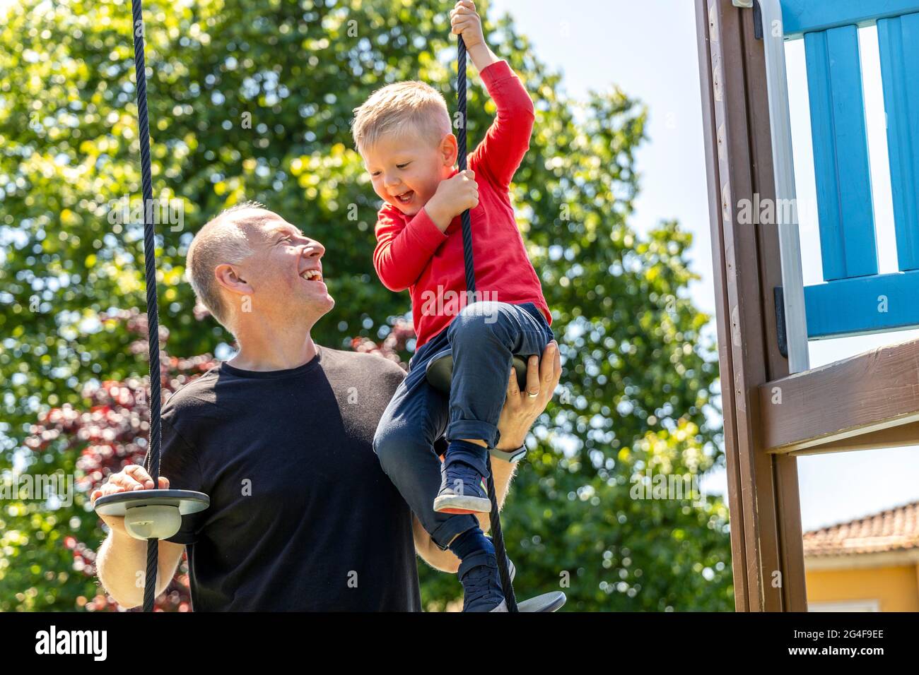Vater spielt mit seinem 3-jährigen Sohn auf dem Spielplatz Stockfoto
